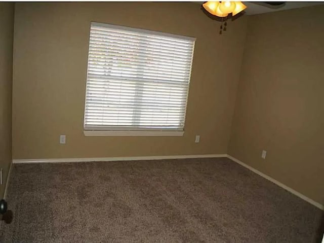 empty room featuring dark carpet and ceiling fan