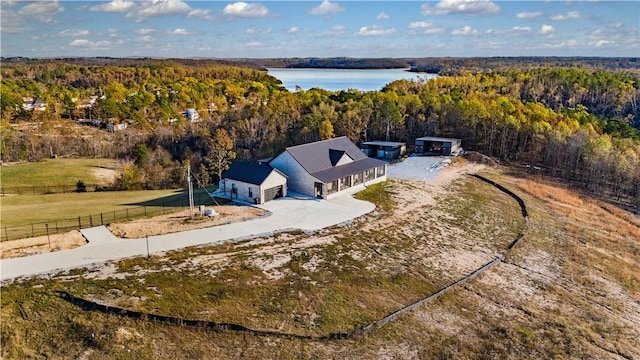 bird's eye view with a water view and a wooded view