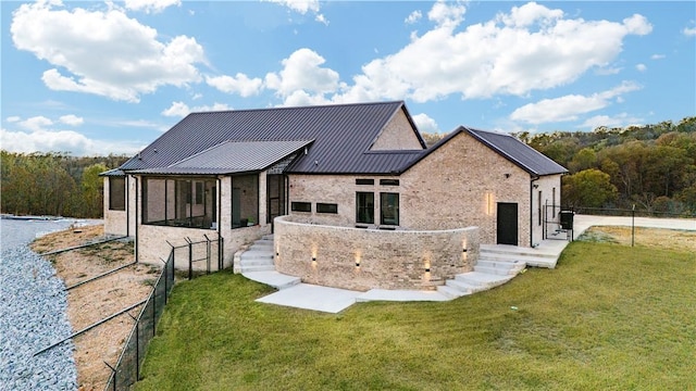 view of front of house featuring metal roof, a front yard, and fence