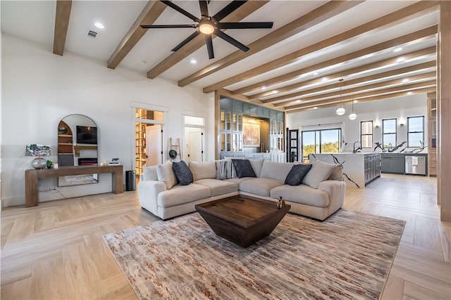 living room featuring recessed lighting, visible vents, beamed ceiling, and ceiling fan