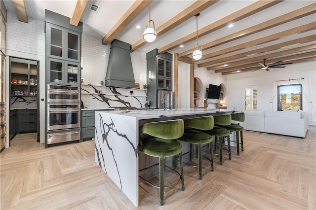 kitchen with visible vents, double oven, custom range hood, gray cabinets, and a warming drawer