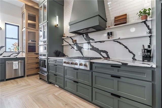 kitchen with gray cabinets, stainless steel appliances, custom range hood, a warming drawer, and backsplash