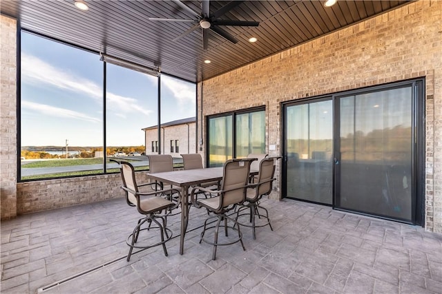 sunroom featuring wood ceiling and a ceiling fan