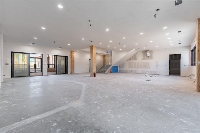 unfurnished living room with stairs and recessed lighting