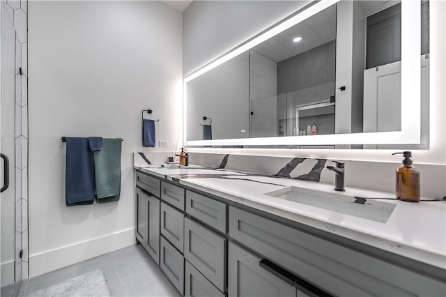 full bathroom featuring tile patterned floors, a stall shower, a sink, double vanity, and baseboards