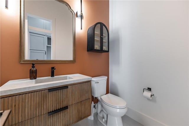 half bathroom featuring vanity and toilet