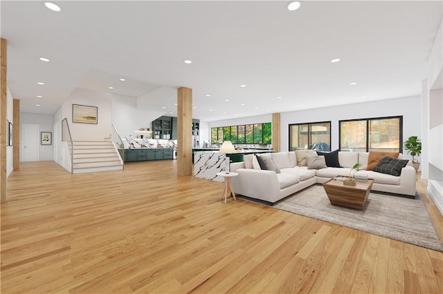 living room with stairway, recessed lighting, and light wood finished floors