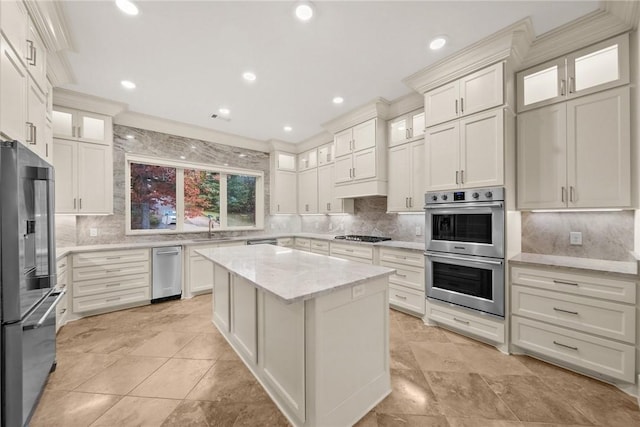 kitchen with light stone counters, crown molding, a kitchen island, and stainless steel appliances