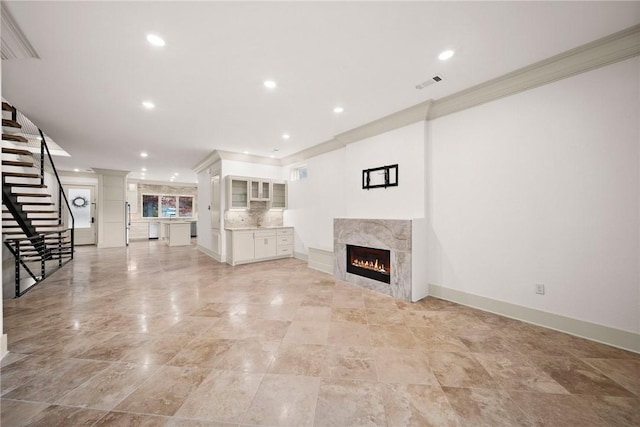 unfurnished living room with ornamental molding and a fireplace