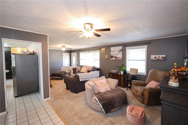 living room featuring ceiling fan, light tile patterned floors, a textured ceiling, and ornamental molding