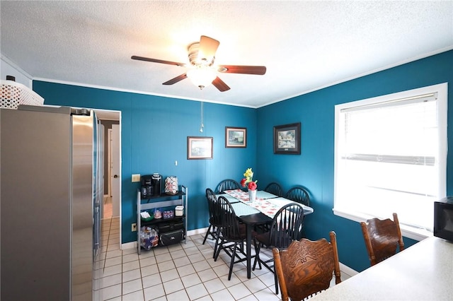 dining space featuring ceiling fan, light tile patterned flooring, and a textured ceiling