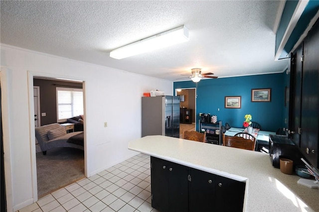 kitchen with stainless steel fridge with ice dispenser, ceiling fan, light carpet, and a textured ceiling