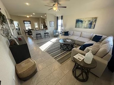 living room with tile patterned floors, plenty of natural light, and ceiling fan