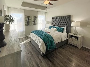 bedroom with dark hardwood / wood-style flooring, multiple windows, and ceiling fan