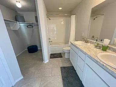 full bathroom with tile patterned floors, vanity, washtub / shower combination, and toilet