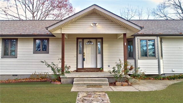 view of front of house with a front yard, roof with shingles, and crawl space