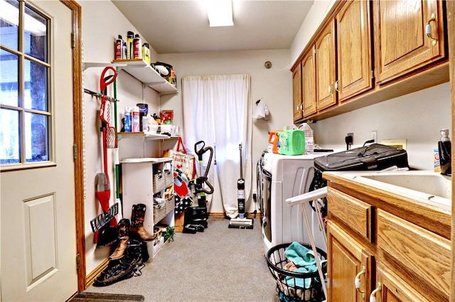 clothes washing area featuring washer and clothes dryer, light colored carpet, and sink