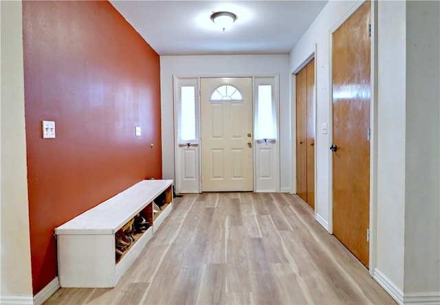 foyer entrance featuring baseboards and light wood-style floors