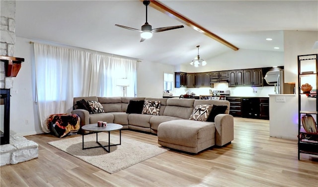 living area with a stone fireplace, lofted ceiling with beams, light wood-type flooring, and ceiling fan