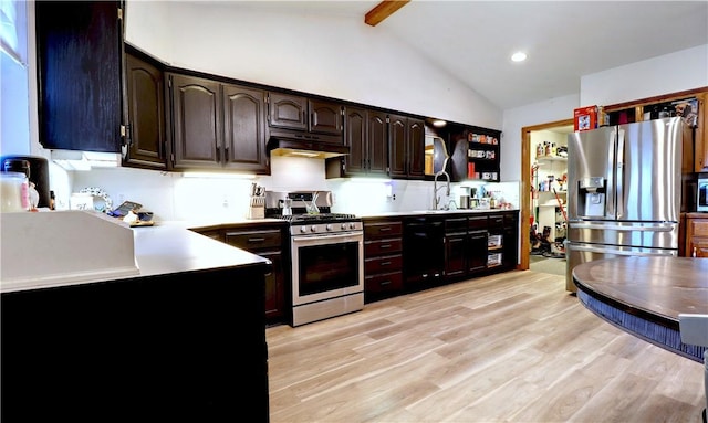 kitchen with light wood-style flooring, vaulted ceiling with beams, under cabinet range hood, and stainless steel appliances