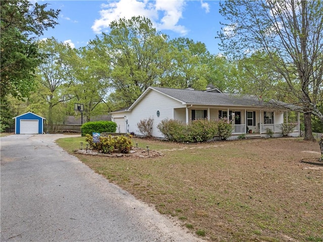 ranch-style home with driveway, an outbuilding, a porch, a front yard, and a garage