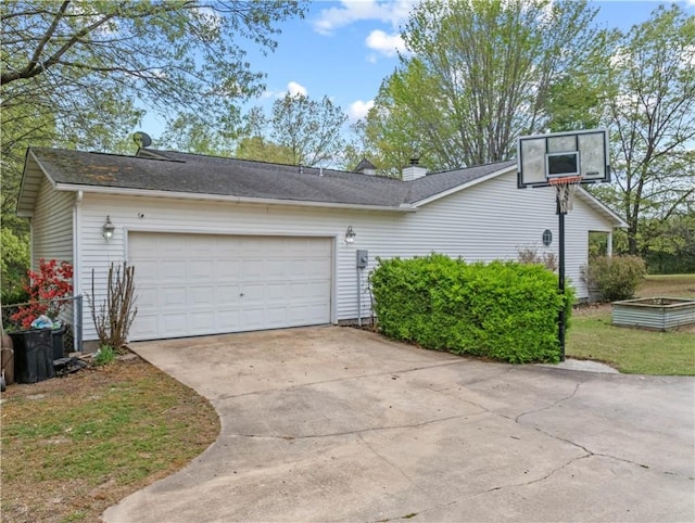 view of side of property featuring concrete driveway and an attached garage