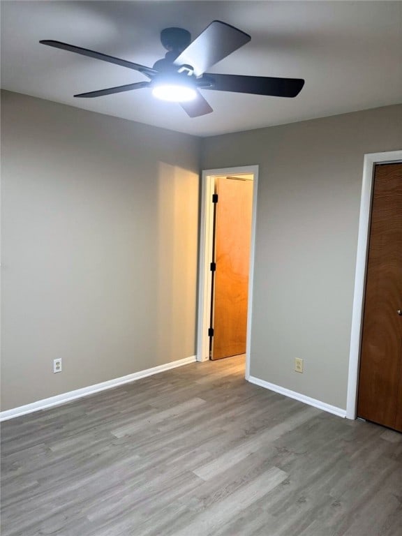 unfurnished bedroom featuring ceiling fan, light wood-type flooring, and a closet