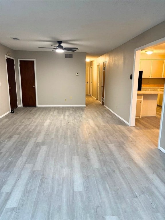 unfurnished living room featuring ceiling fan and light wood-type flooring