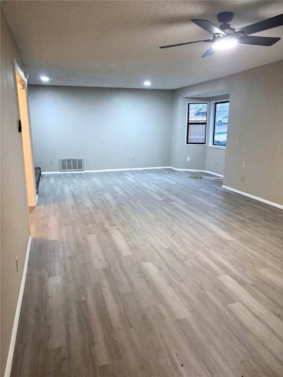 unfurnished room with a textured ceiling, light hardwood / wood-style flooring, and ceiling fan