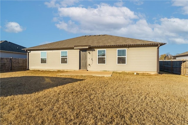 rear view of property with a lawn and a patio