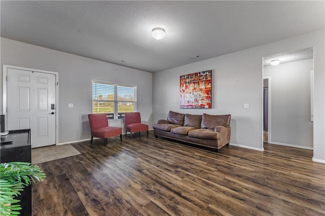 living room with wood-type flooring and a textured ceiling