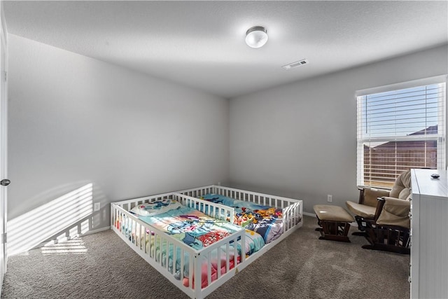 bedroom featuring carpet flooring and a textured ceiling