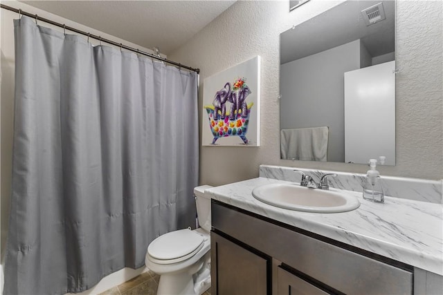 bathroom with tile patterned floors, vanity, toilet, and a textured ceiling