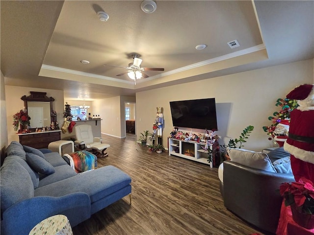 living room featuring wood-type flooring, a tray ceiling, ceiling fan, and crown molding