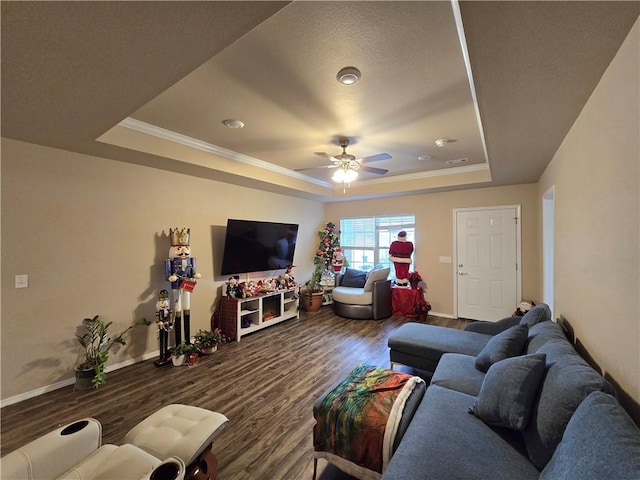 living room with a tray ceiling, ceiling fan, ornamental molding, and hardwood / wood-style flooring