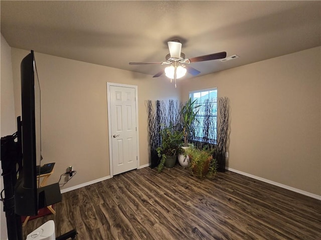 spare room with ceiling fan and dark wood-type flooring