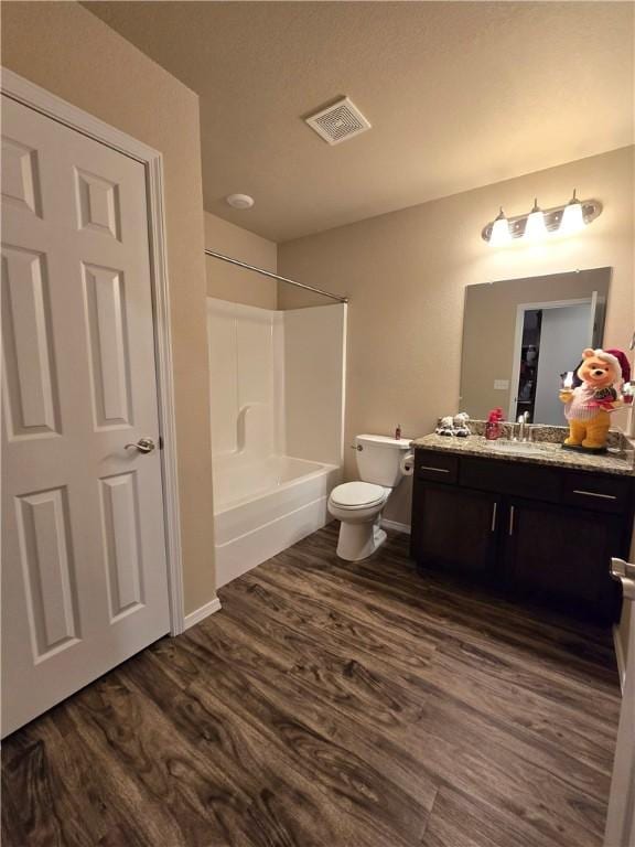 full bathroom featuring hardwood / wood-style flooring, vanity, toilet, and washtub / shower combination