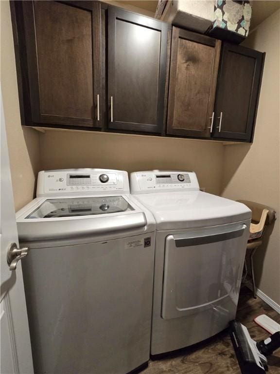 washroom with washing machine and dryer and cabinets