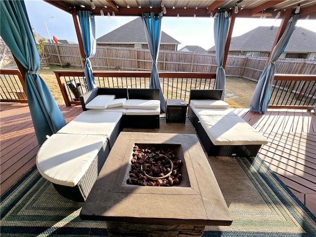 wooden terrace featuring an outdoor living space with a fire pit