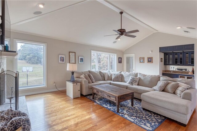 living room featuring bar, light hardwood / wood-style floors, vaulted ceiling, and ceiling fan