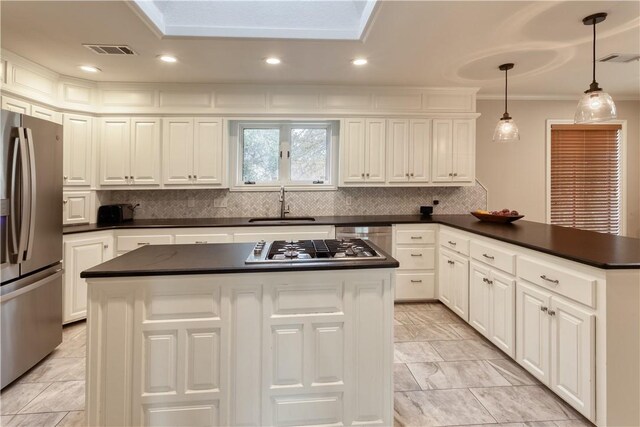 kitchen with backsplash, stainless steel appliances, white cabinetry, and hanging light fixtures