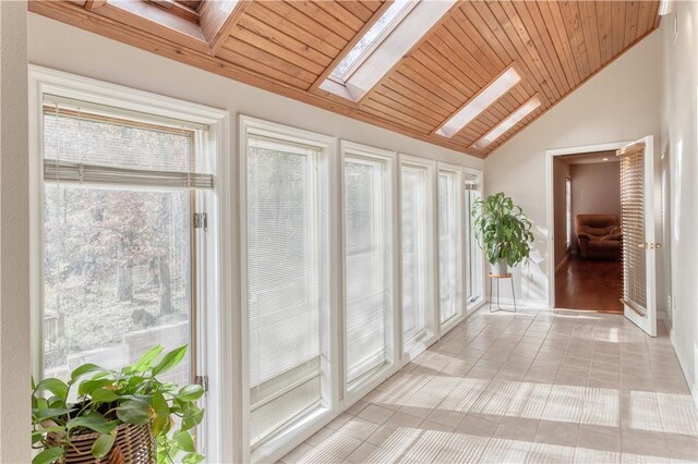 interior space featuring a healthy amount of sunlight, lofted ceiling with skylight, and wooden ceiling