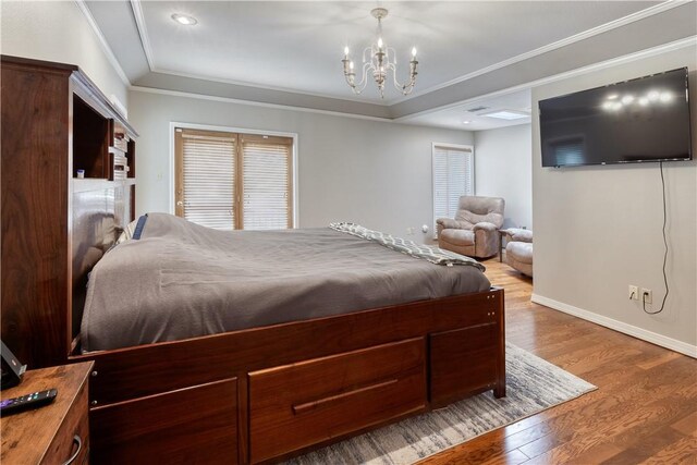 bedroom with hardwood / wood-style floors, a notable chandelier, and ornamental molding