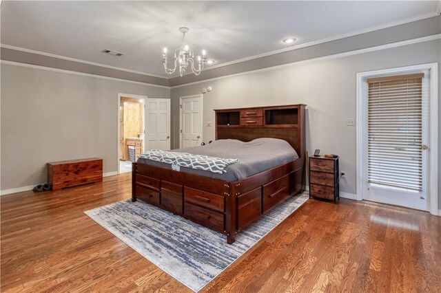 bedroom featuring crown molding, ensuite bathroom, a notable chandelier, and hardwood / wood-style flooring