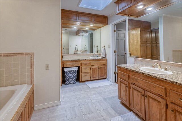 bathroom featuring a washtub, vanity, a skylight, and tile patterned floors