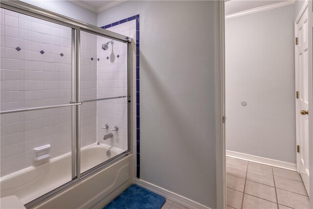 bathroom with tile patterned flooring, bath / shower combo with glass door, and ornamental molding