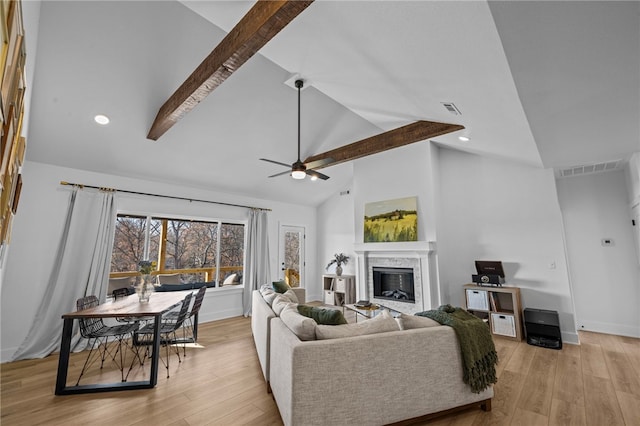 living room with beam ceiling, high vaulted ceiling, light hardwood / wood-style flooring, and ceiling fan