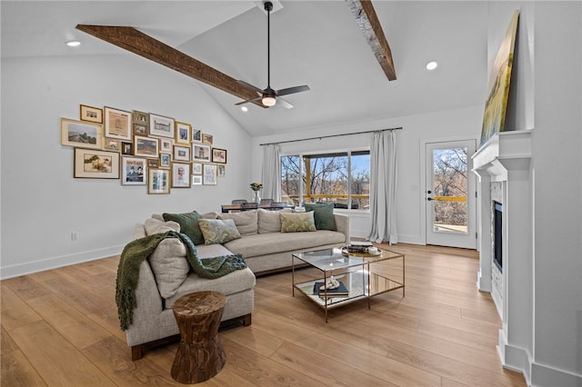 living room featuring beam ceiling, light hardwood / wood-style flooring, and ceiling fan