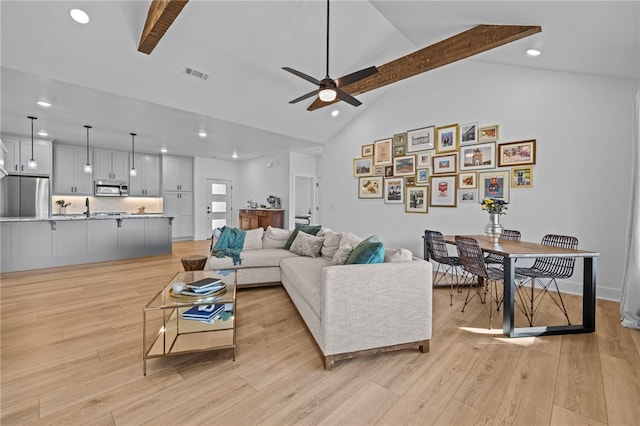 living room with ceiling fan, light hardwood / wood-style flooring, beamed ceiling, and high vaulted ceiling