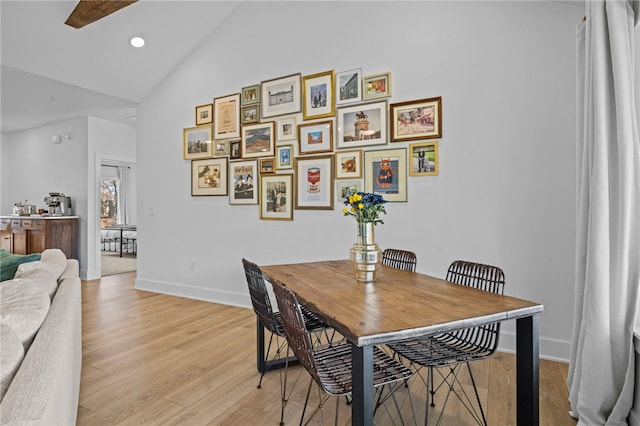 dining space with light hardwood / wood-style floors and lofted ceiling